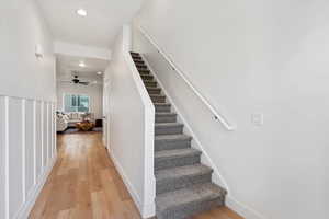 Stairs featuring hardwood / wood-style floors and ceiling fan