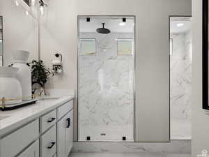 Bathroom featuring a tile shower and vanity