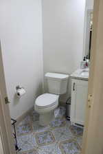 Bathroom with toilet, tile patterned flooring, and vanity