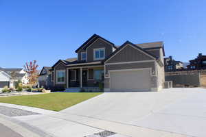 Craftsman house with a front lawn and a garage