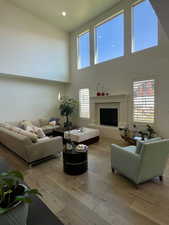 Living room featuring light hardwood / wood-style flooring and a towering ceiling