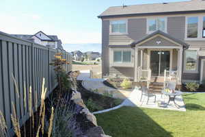 Back of house with a patio and a lawn