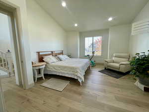 Bedroom featuring light wood-type flooring and vaulted ceiling