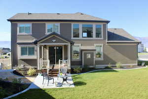 Rear view of house featuring a lawn and a patio area