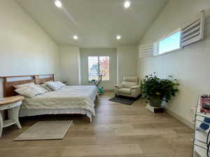 Bedroom featuring light hardwood / wood-style floors and vaulted ceiling