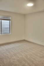 Empty room featuring light colored carpet