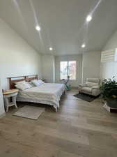 Bedroom featuring light hardwood / wood-style flooring and vaulted ceiling