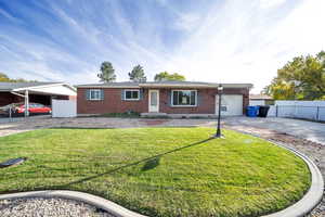 Ranch-style. Brick house with a front yard and a 1-car garage