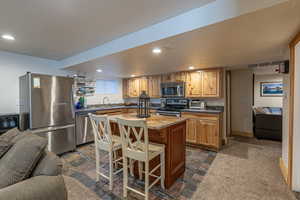 Kitchen with sink, a center island, stainless steel appliances, and a textured ceiling