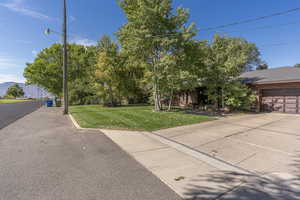 View of front of property featuring a mountain view, a front yard, and a garage