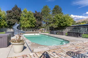 View of swimming pool featuring a water slide and a patio area