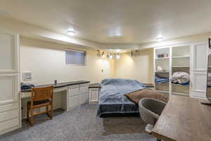 Carpeted bedroom featuring built in desk