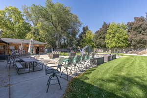 View of pool featuring a playground, a yard, a water slide, and a patio area