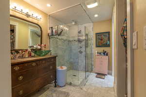 Bathroom with vanity and a shower with door