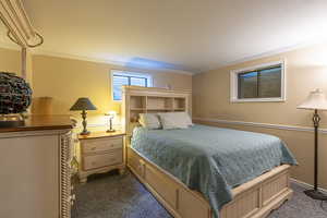 Carpeted bedroom with ornamental molding