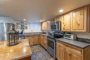 Kitchen featuring appliances with stainless steel finishes, sink, and a textured ceiling