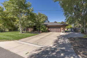 View of front of house with a front yard and a garage