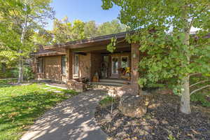 View of front of home with a porch and a front lawn