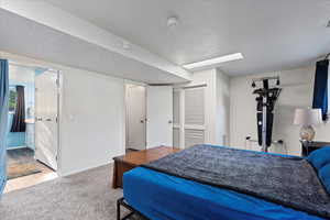 Bedroom featuring connected bathroom, a closet, hardwood / wood-style floors, and a textured ceiling