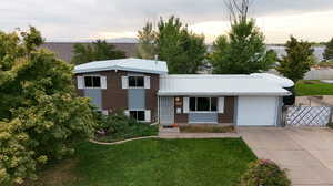 Split level home featuring a lawn and a garage