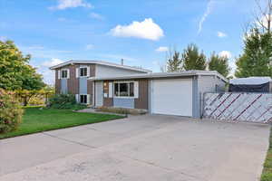 View of front facade featuring a front yard and a garage