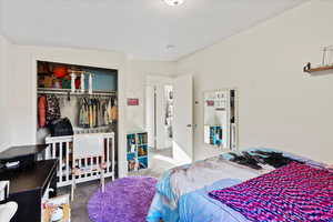 Carpeted bedroom with a closet