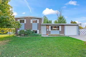 Split level home featuring a front yard and a garage