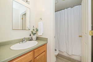 Full bathroom featuring shower / tub combo, hardwood / wood-style floors, vanity, and toilet