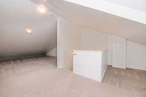 Bonus room featuring light carpet and lofted ceiling