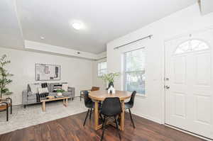 Dining space with dark hardwood / wood-style floors, a wealth of natural light, and a textured ceiling