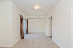 Corridor featuring light carpet and a textured ceiling