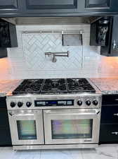 Kitchen with double oven range, backsplash, and light granite counters