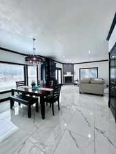 Dining space with ornamental molding, and chandelier