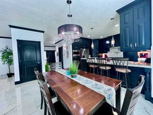 Dining area with crown molding, and chandelier