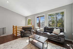 Living room with lofted ceiling and hardwood / wood-style floors