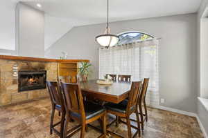 Dining area with a fireplace and lofted ceiling