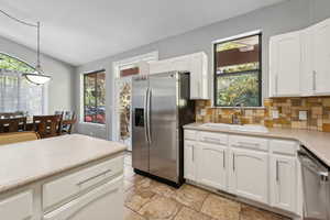 Kitchen featuring sink, decorative light fixtures, white cabinetry, appliances with stainless steel finishes, and a healthy amount of sunlight