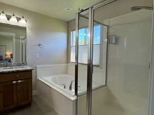 Bathroom with tile patterned floors, vanity, and independent shower and bath