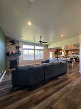 Living room featuring a fireplace, ceiling fan, and dark hardwood / wood-style floors