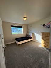 Unfurnished bedroom featuring dark carpet