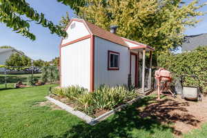 View of outbuilding featuring a lawn