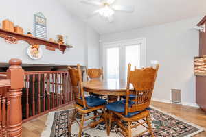 Dining area with ceiling fan, lofted ceiling, and light hardwood / wood-style floors