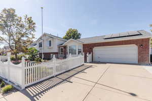 View of front of property with solar panels and a garage