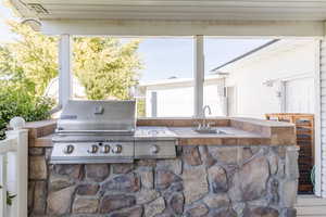 View of patio / terrace featuring grilling area, sink, and exterior kitchen