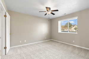 Carpeted empty room with ceiling fan