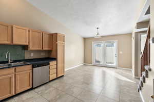 Kitchen with dishwasher, pendant lighting, light tile patterned flooring, and sink