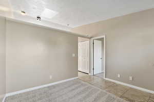 Spare room featuring a skylight and light tile patterned floors