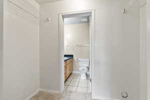 Bathroom featuring vanity, tile patterned flooring, and toilet