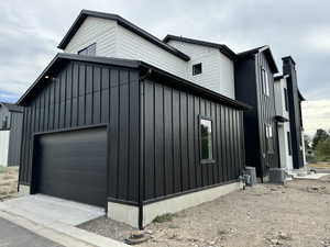 View of home's exterior featuring central AC unit and a garage