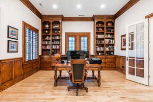 Home office with french doors, crown molding, and light hardwood / wood-style flooring